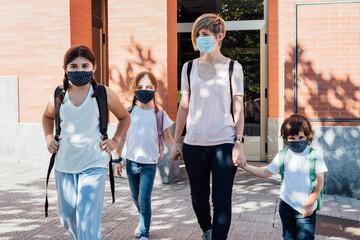 Family leaving home for school at the beginning of the course with masks on their faces