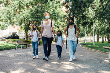 Family going to school at the beginning of the course with masks on their faces