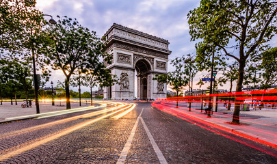 Fototapeta na wymiar Lightrails of cars in front of The Arc de Triomphe de l'Étoile. It is one of the most famous monuments in Paris, France, standing at the western end of the Champs-Élysées.