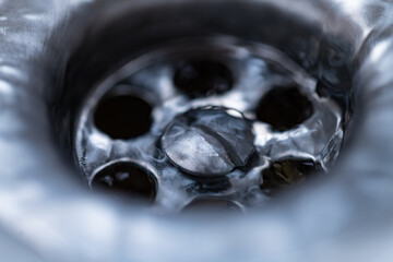 macro close-up if water flowing through a drain in a sink. High quality photo