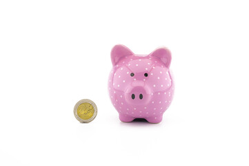 Cute pink piggy bank and euro coin on white