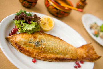 Deep-fried sea fish in flour batter with vegetable side dish and cranberry lemon