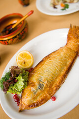Deep fried sea fish in flour batter with vegetable side dish and lemon