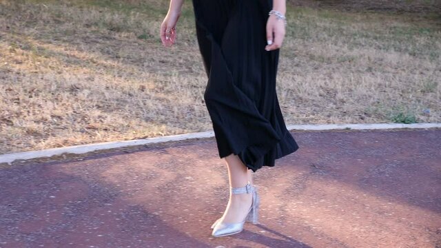 elegant beautiful woman's legs walking slowly at park - slow motion
