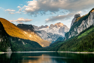 Sunny sunset colorful summer alpine view. Peaceful mountain lake with clear transparent water and reflections. Gosauseen or Vorderer Gosausee lake Salzkammergut Upper Austria. Dachstein summit glacier