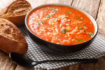 Thick vegetarian tomato soup with rice close-up in a bowl on the table. horizontal - obrazy, fototapety, plakaty