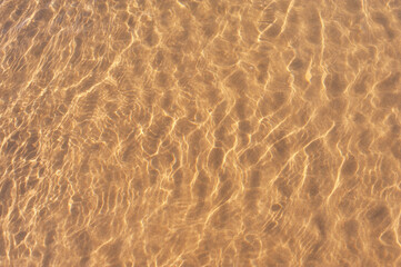 Fototapeta na wymiar The glare of the sun on the water near the shore. Photos on the beach on a Sunny day