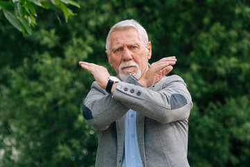 Fototapeta premium An elderly man in stylish clothes in nature. The concept of anger is a ban.