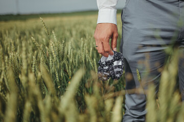 man in a wheat field with baby shoes