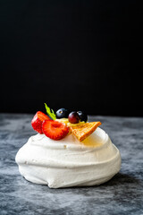 Meringue Dessert Pavlova Cake with Fresh Berries, Strawberries and Dried Orange Slice.