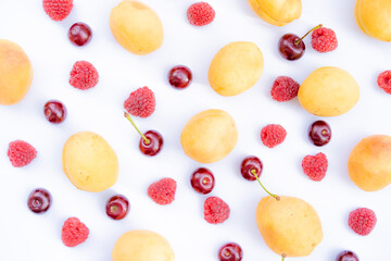 Apricots, cherries and raspberries on a white background