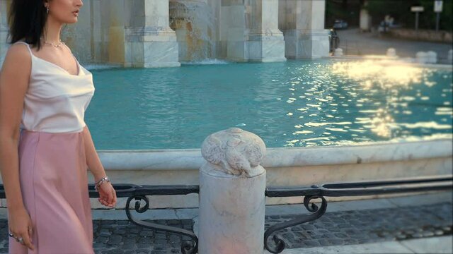 steady cam on water from the fountain and beautiful woman walking around