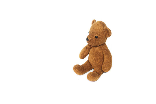Old brown teddy bear on a white background