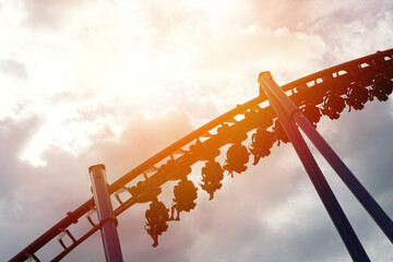 Roller coaster in the amusement park with the sunset background.
