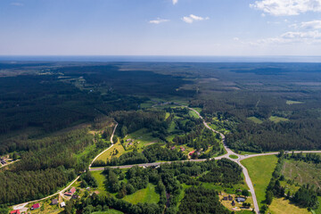 Aerial view of cloudy sunny day. Countryside surrounded by green fields, rivers and trees.