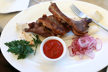 Grilled lamb loins with red onions and sauce