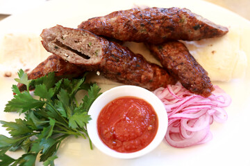 Veal lula kebab with red onions and sauce