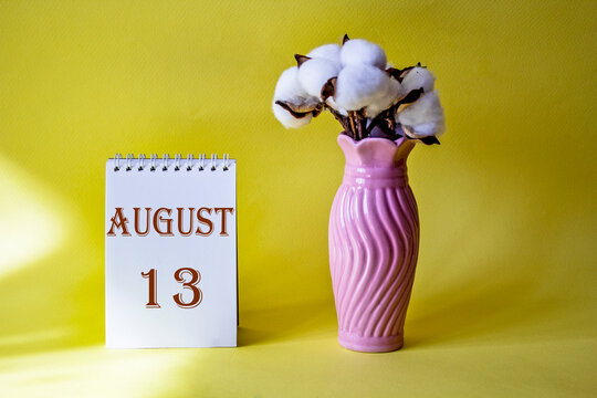 Calendar with text 13 august on yellow background and with a vase of flowers