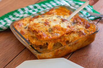 Traditional italian lasagna with cheese. On a wooden background.