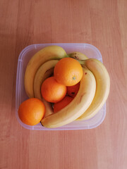 Bananas and oranges in a deep bowl