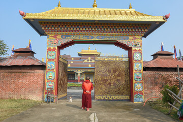 Monk in front of the entrance door at the monastic zone of Lumbini on Nepal