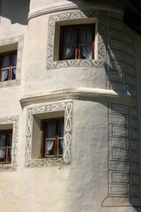 Fototapeta na wymiar Traditional windows of a white house with frescoed decorations, Engadin valley, Graubunden canton, Switzerland, Europe