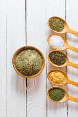 Wooden bowl and spoons filled with ground spices