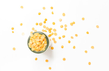 Top view and copy space on white studio. Soybean seed in clear glass bottle and spread on white floor.