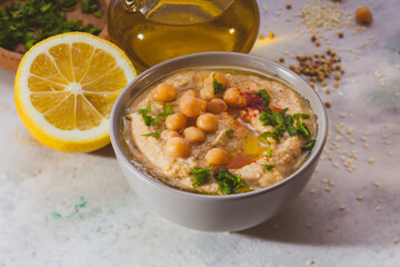 Bowl of hummus with chick peas and greenery on top