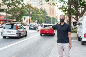 Fototapeta na wymiar young man with protective mask against corona virus on the street