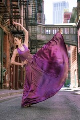 Full Length Of Young Woman Dancing On Street Amidst Buildings In City