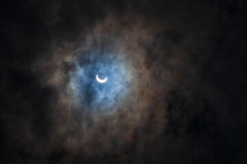 Fototapeta na wymiar Surreal Dramatic Solar Eclipse Covered By Clouds. Natural Phenomenon.
