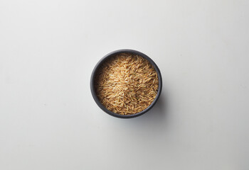 Top view shot of brown rice on white background.