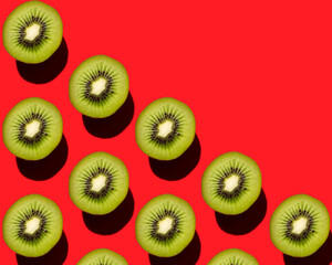 Fototapeta premium Beautiful pattern of kiwi fruit on a red background.