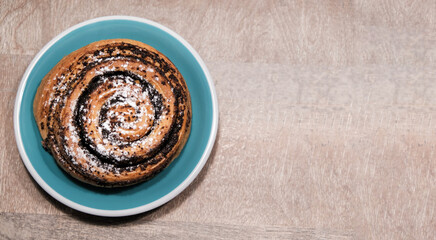 Poppy seed bun on wooden background. Place for text, copy space