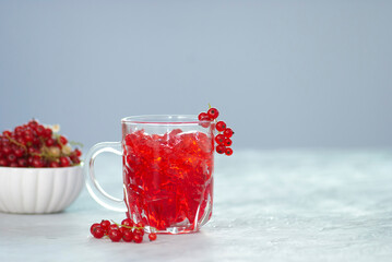 Red currant jam on the light gray background. Summer natural tasty jam fruits berries red beautiful picture copy space