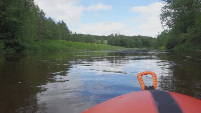 River rafting in summer. Packrafting in wilderness. First person view from a packraft of river bank with forest. Derzha River, Tver Region, Russia.