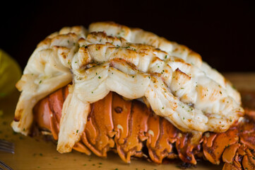 Lobster tail, served with drawn butter and lemon wedges. Maine lobster tail, classic American restaurant favorite. Seasoned with salt and pepper and garnished with Italian parsley.