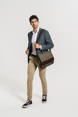 Photo of confident businessman looking aside while walking with bag