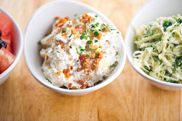 Steakhouse side dishes. Asparagus, salad, tomatoes, mashed potatoes, red onions, cream cauliflower, pickled peppers, seasoned meats served in cast iron skillet. Traditional appetizer items.