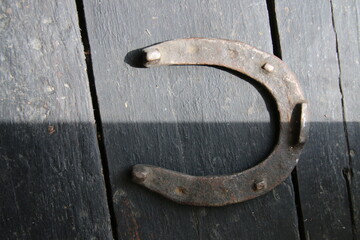 Symbol of luck. Old metal rusted horseshoe on a vintage table.