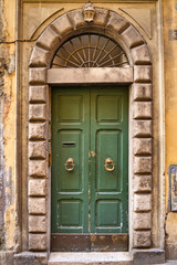 Fototapeta na wymiar vintage residential house wooden entrance door and arched frame. Architekture in Rome, Italy