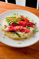 Frittata or omelette lobster avocado. Egg-based Italian dish w/ scrambled eggs, enriched with additional ingredients. classic seafood restaurant brunch/breakfast menu item. Maine lobster frittata. 