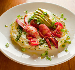 Frittata or omelette lobster avocado. Egg-based Italian dish w/ scrambled eggs, enriched with additional ingredients. classic seafood restaurant brunch/breakfast menu item. Maine lobster frittata. 