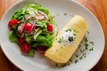 Omelette. Classic traditional american brunch/breakfast menu item served at traditional american restaurant. Farm fresh eggs, cooked in butter with fresh vegetables pork/bacon and served with salad 