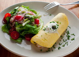 Omelette. Classic traditional american brunch/breakfast menu item served at traditional american restaurant. Farm fresh eggs, cooked in butter with fresh vegetables pork/bacon and served with salad 