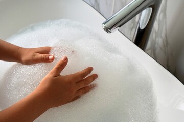 Fototapeta premium close up of child washing hands in bathroom