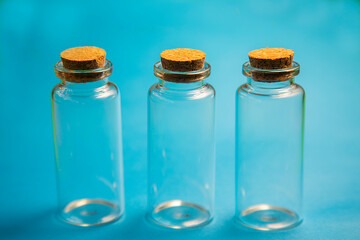 3 small empty glass container on a blue background