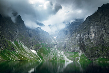 Scenic shot of beautiful green hills and mountains in white clouds and reflection on the lake Morskie Oko lake, High Tatras, Zakopane © WellStock
