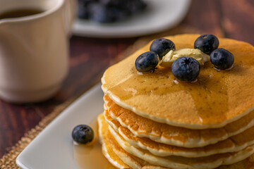 Pancake with butter and blueberries on topping served with syrup